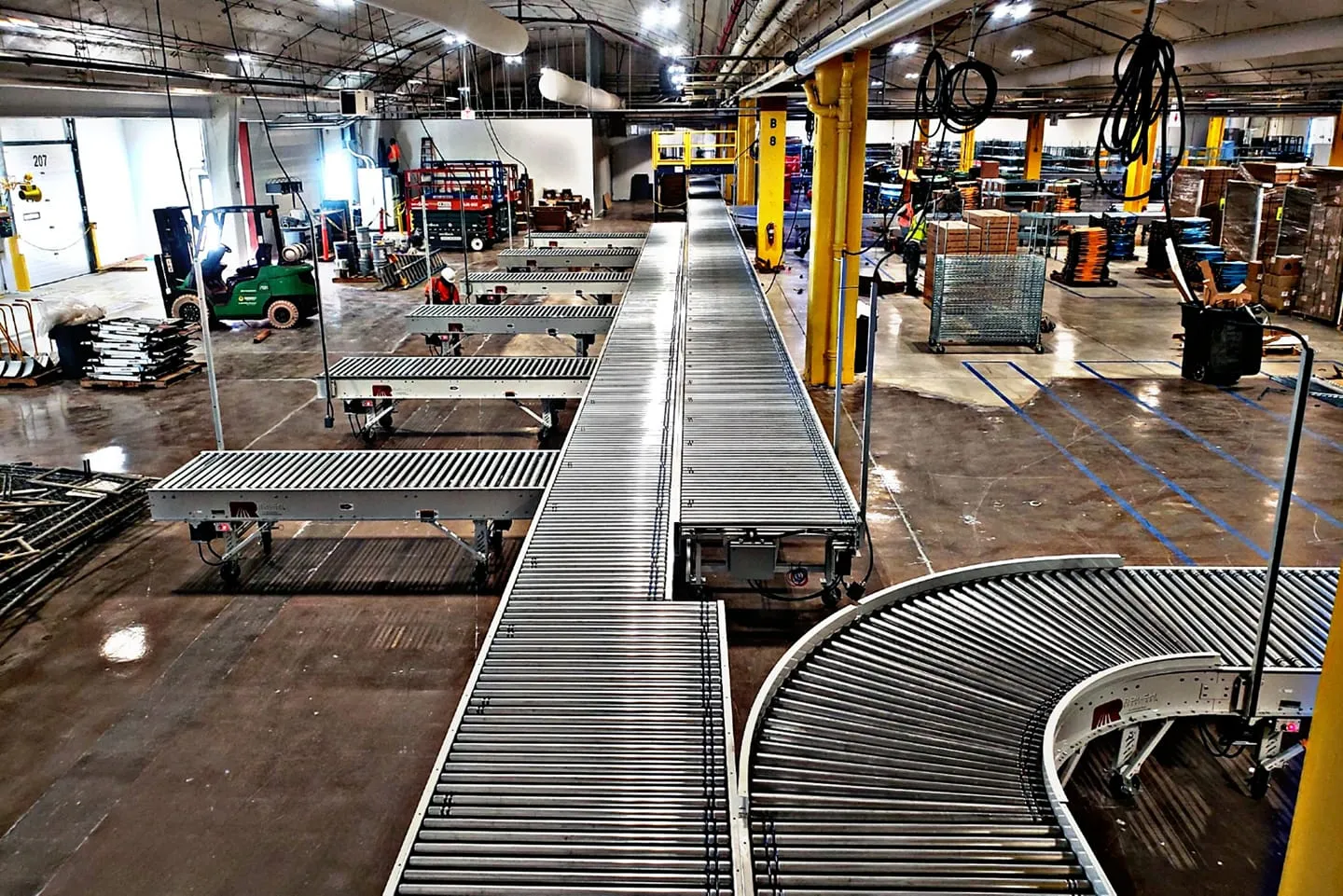 Long roller conveyor lines running through a clean well-lit industrial facility