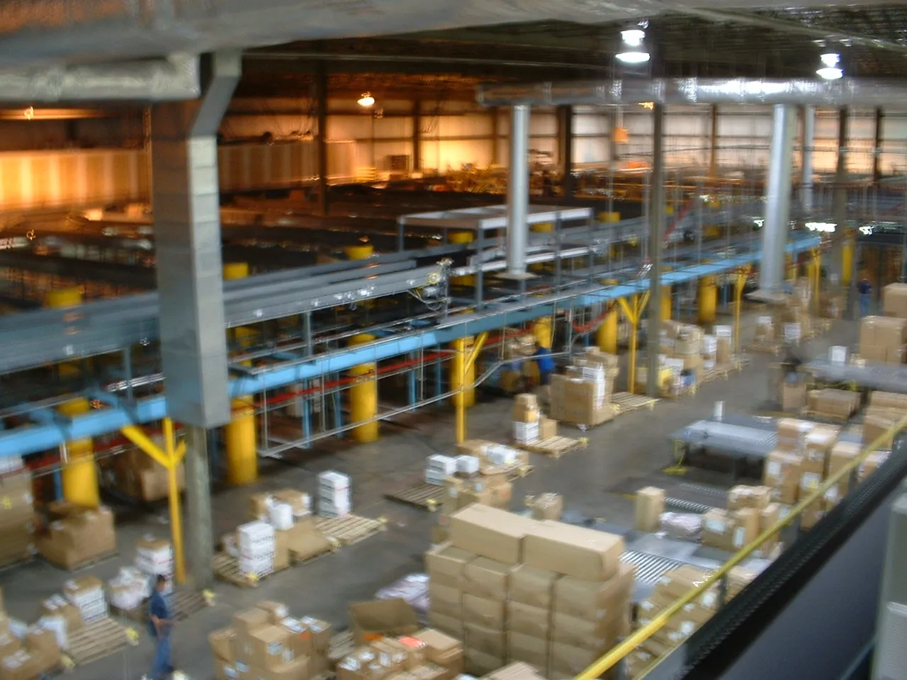 Elevated view of a busy distribution center with active conveyor lines and package handling