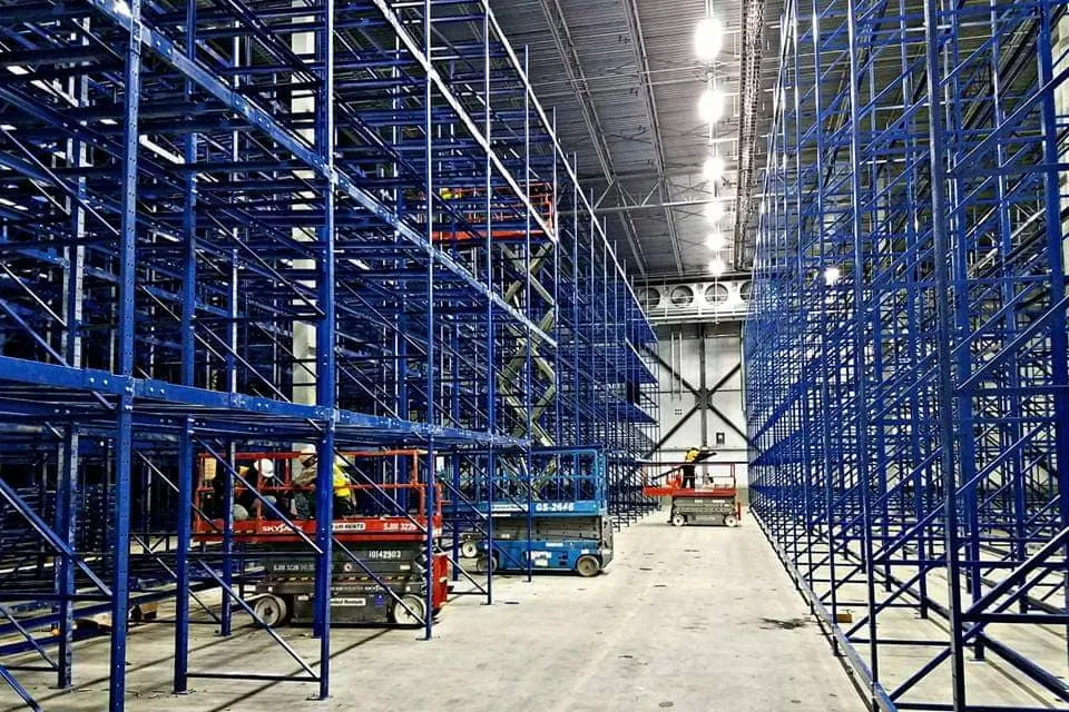 Large-scale blue pallet racking and conveyor system installation using scissor lifts