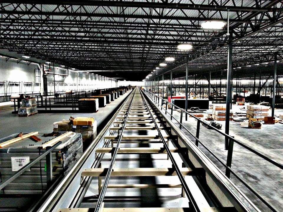 Long clean roller conveyor system installed in a spacious empty warehouse