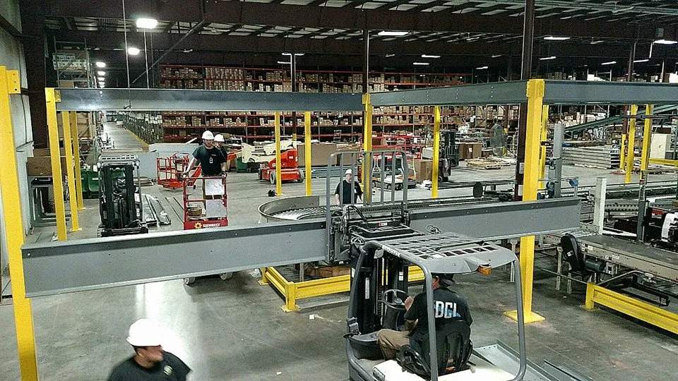 Worker performing maintenance on an overhead conveyor from a scissor lift
